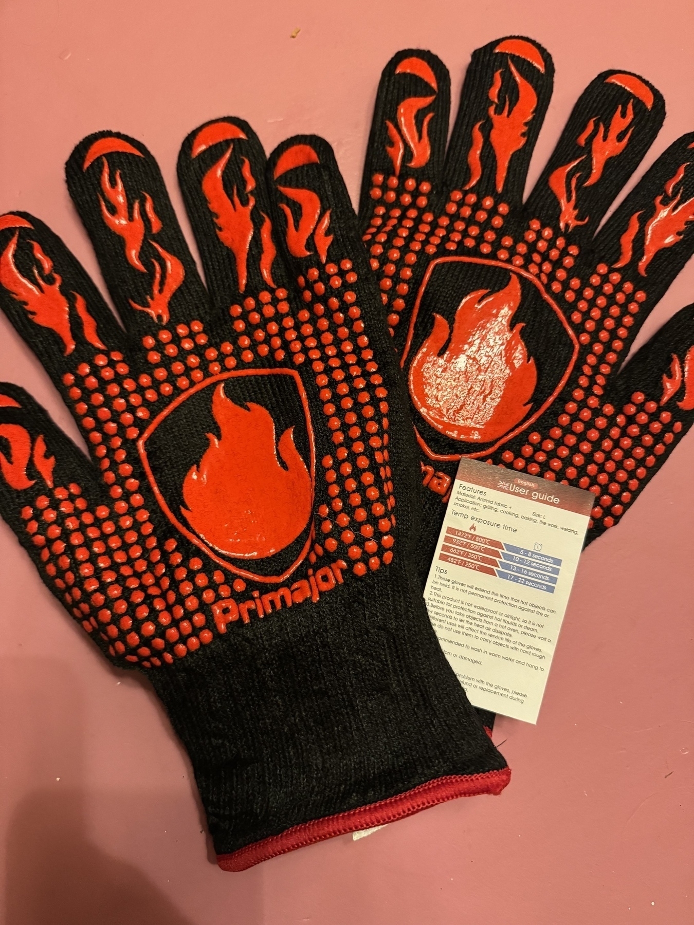 Photo of Grilling BBQ gloves made by Primajor and the guide to how long you can hold certain temperature things from 250°c for 22 seconds to 800°c for 8 seconds 