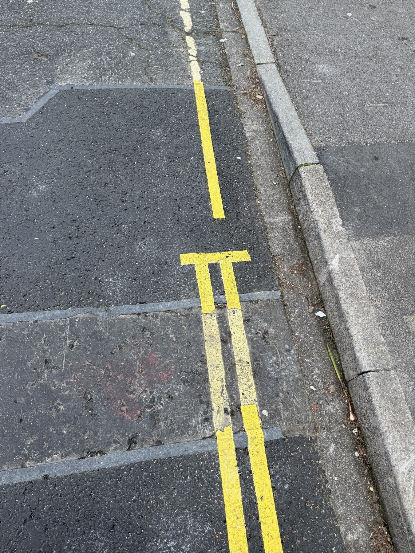 Photo of the yellow parking lines on a UK road where some have been recently repainted connecting to older lines 
