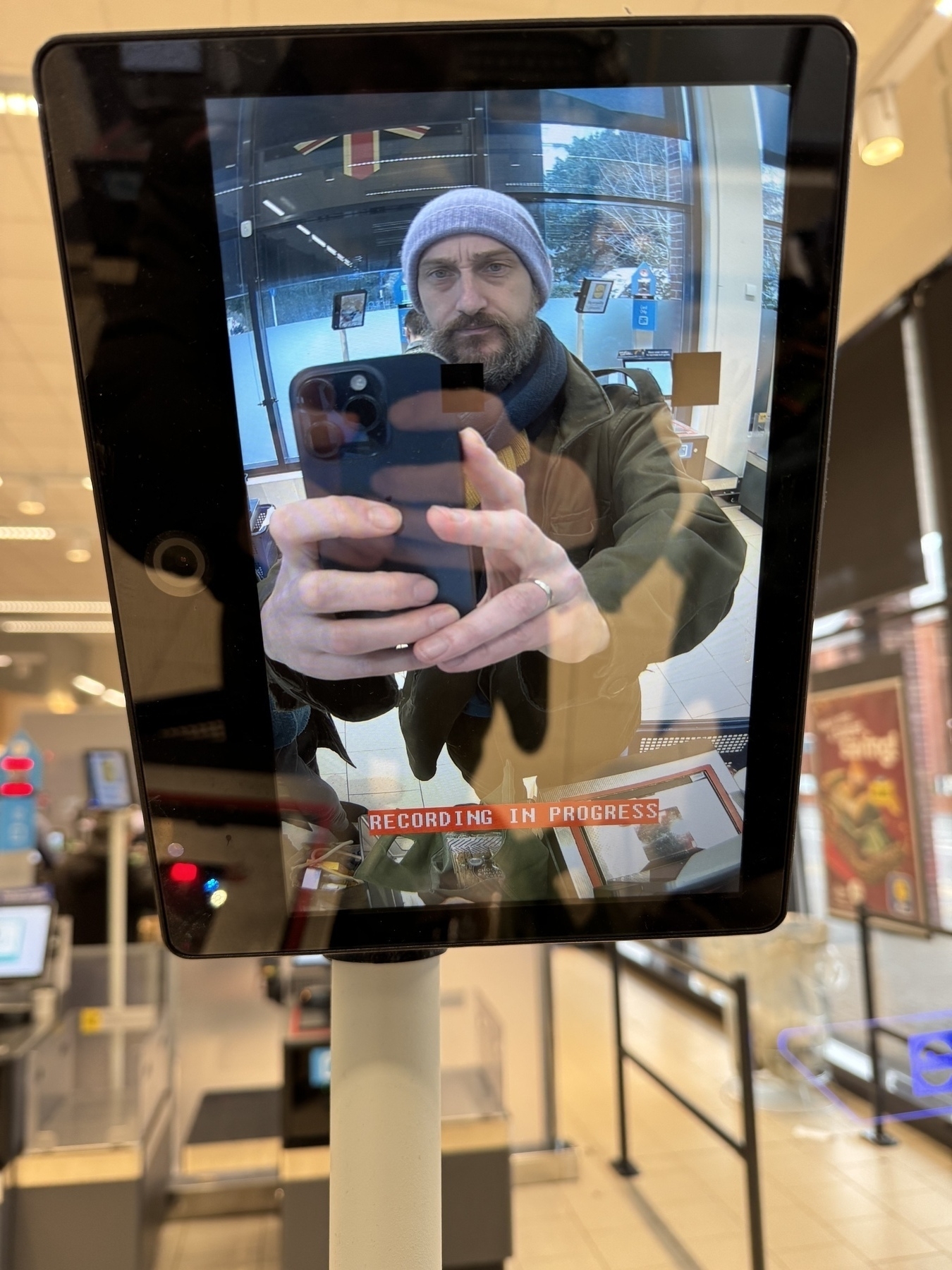 A photo of me taking a recording of the screen of the camera recording me at the self service check out in LIDL