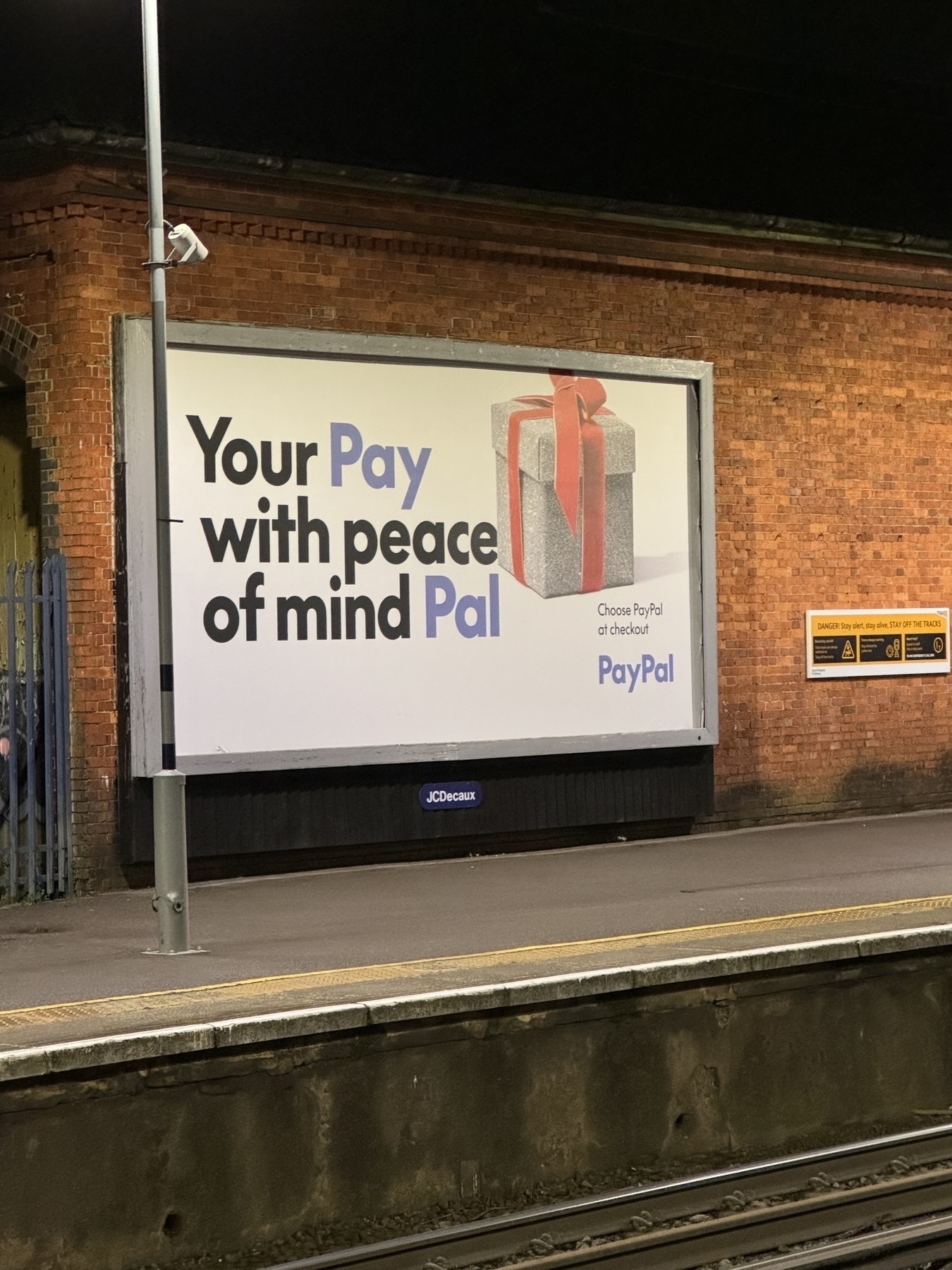 Photo of Billboard image at Winchester station of a PayPal advert promoting peace of mind using PayPal. 