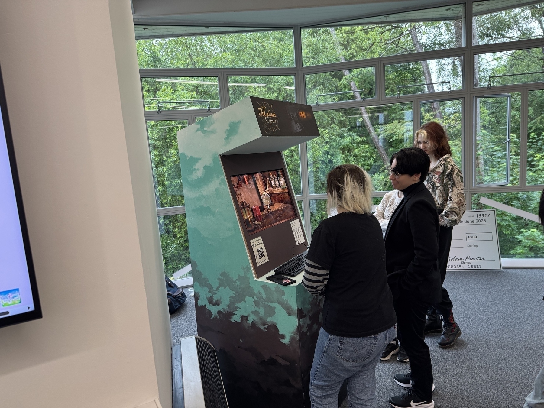 People playing games around arcade machines at degree show event at Winchester School of Art