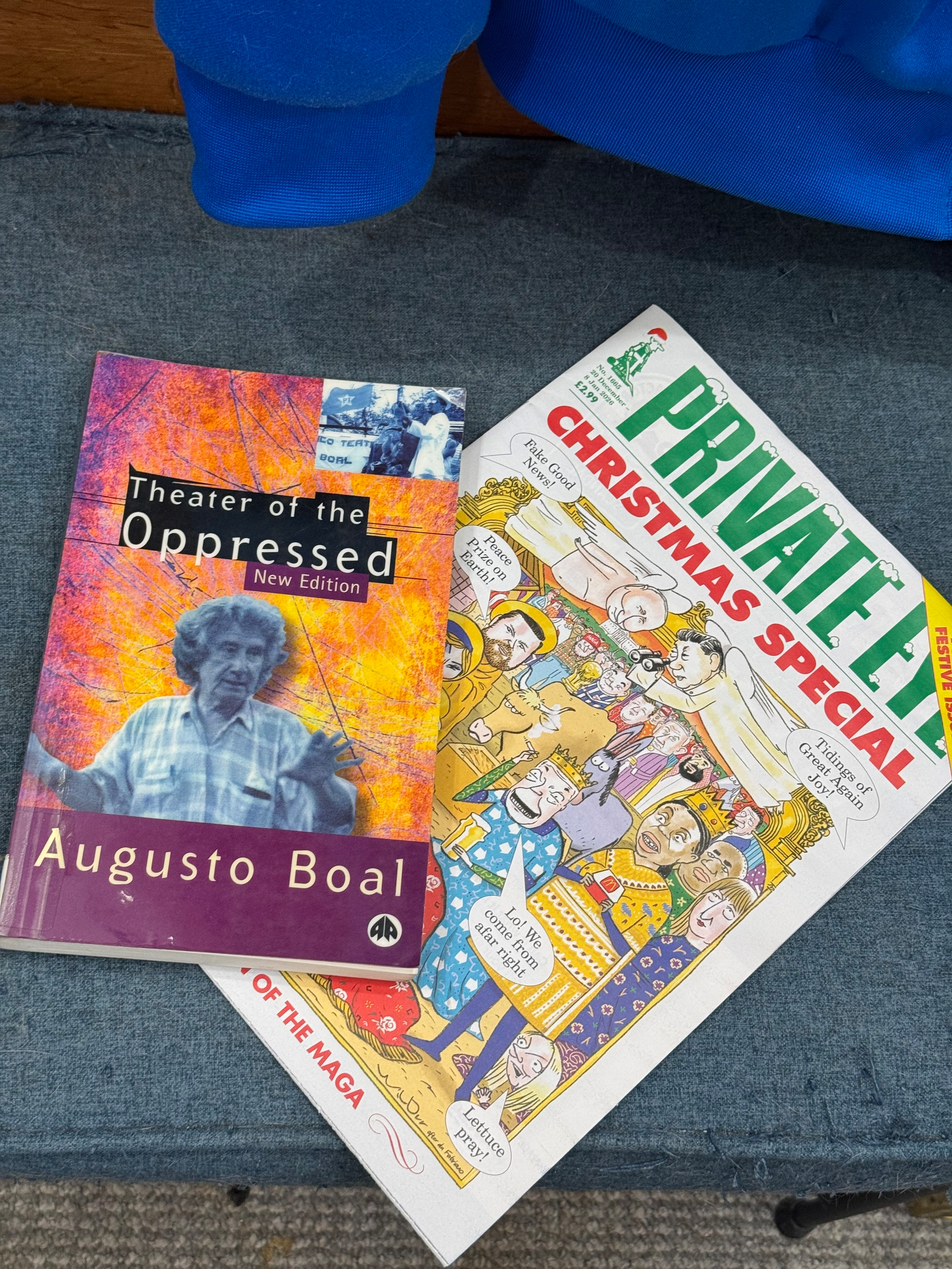 A books and a magazine are placed on a surface: one titled Theater of the Oppressed by Augusto Boal, and the other is a Private Eye Christmas Special magazine.