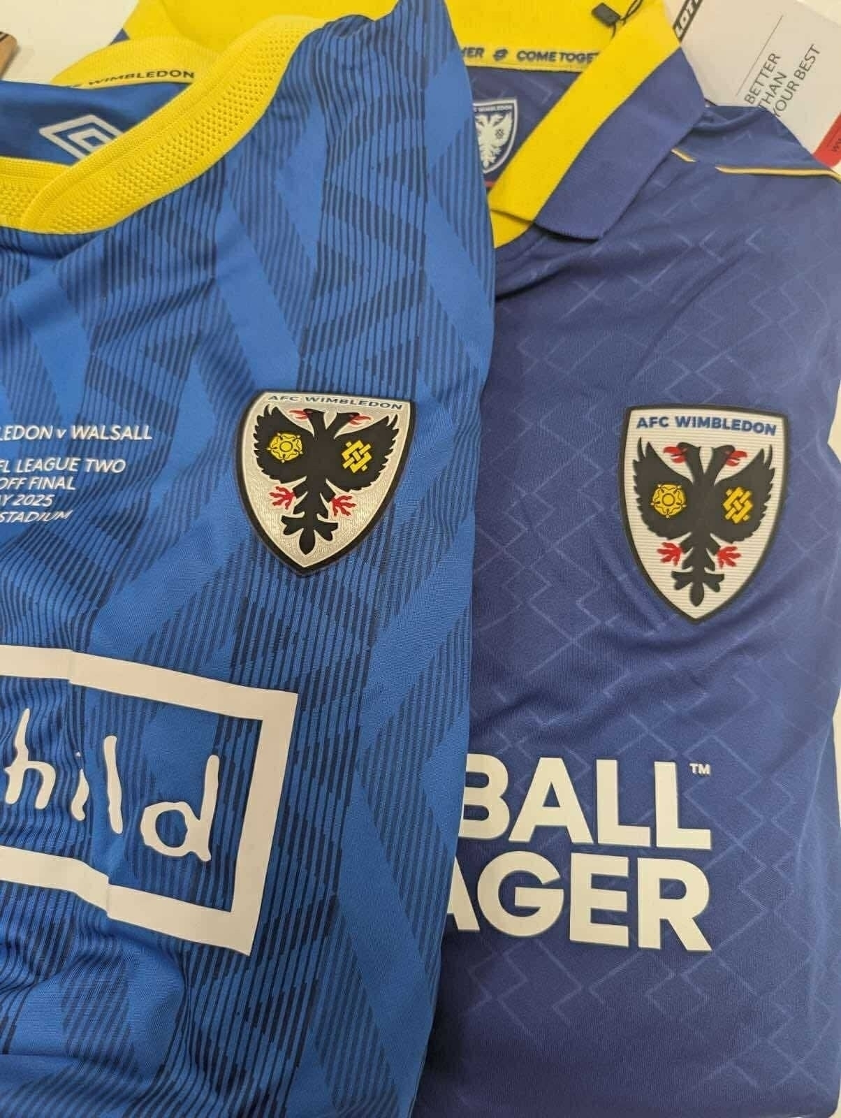 Close up Photo of last years AFC Wimbledon top and this years. On sale 12:00 22 July. Blue looks great 