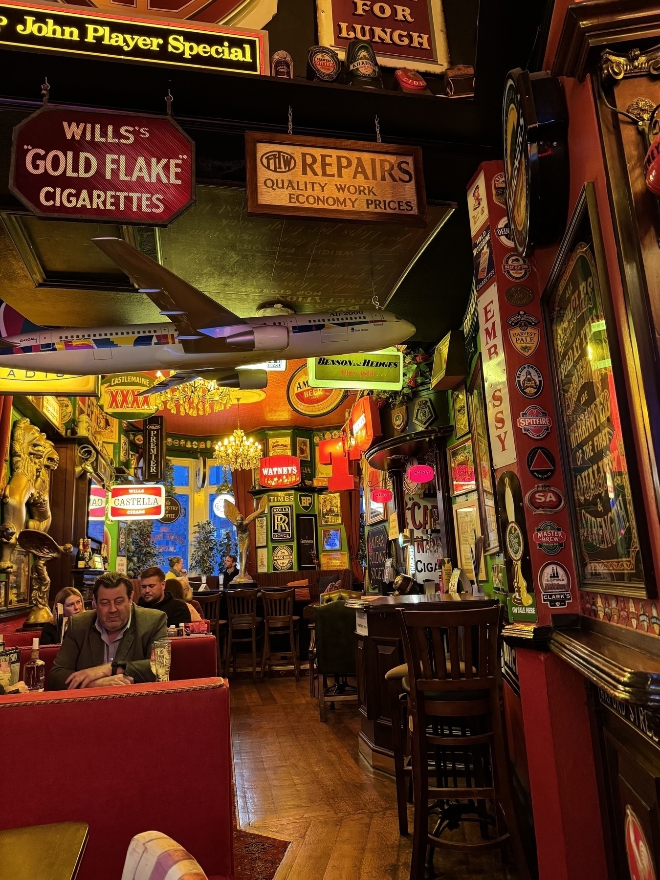 Photo inside of The Hyde Park pub with lots of old beer and cigarette signage and neon style signs 