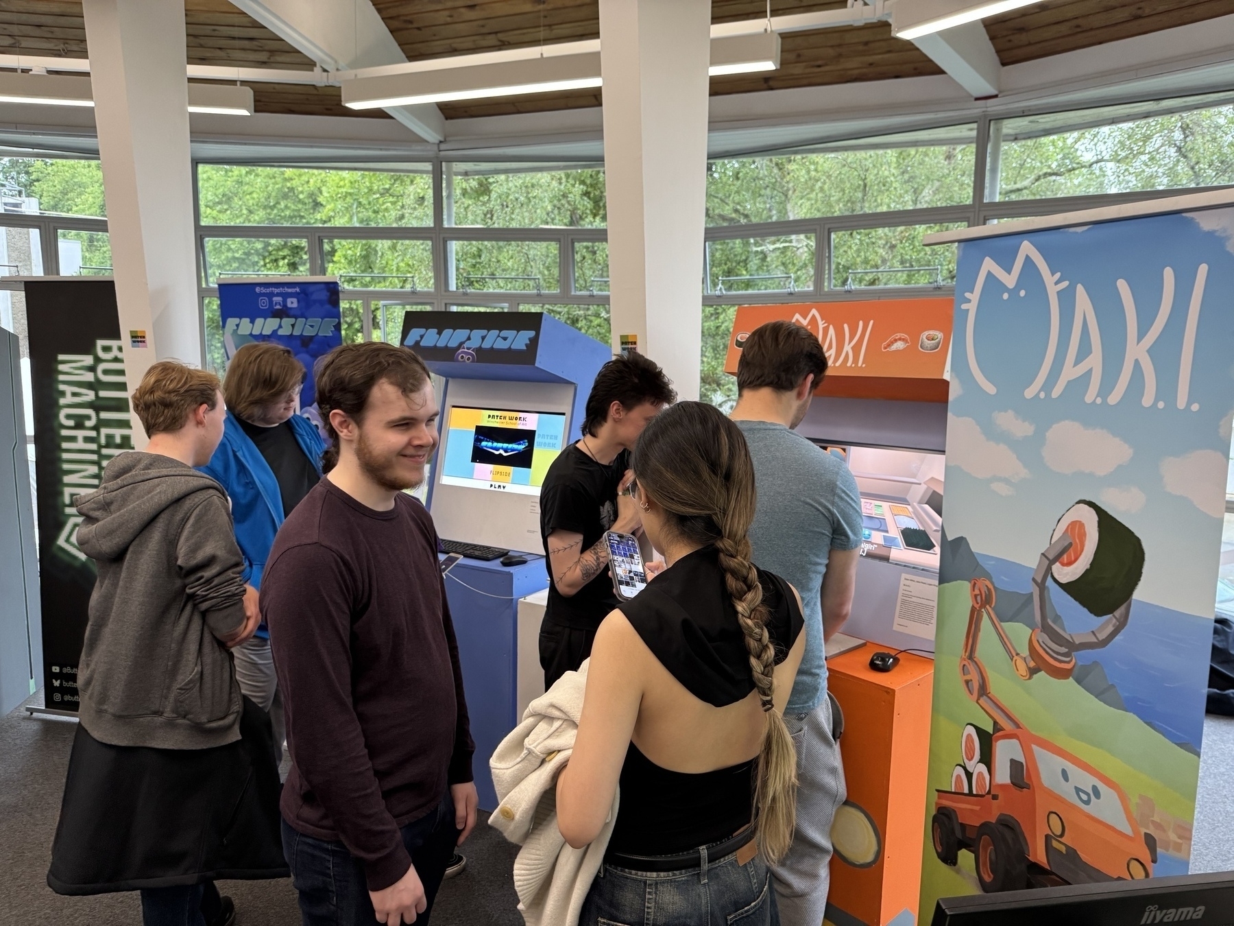 People playing games around arcade machines at Winchester School of Art