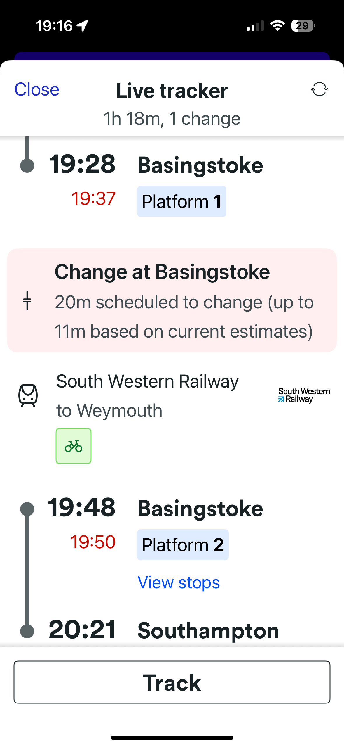 A bearded man (me) wearing sunglasses and a blue jersey is seated on a train.