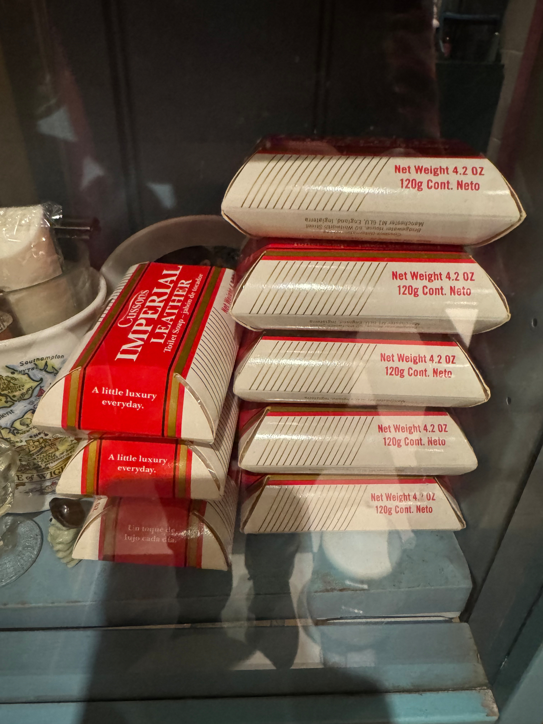 Several boxes of Imperial Leather soap are stacked in a display cabinet.